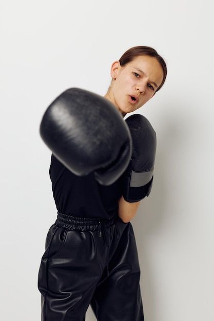 Donna atletica in guantoni da boxe in pantaloni neri e un allenamento fitness maglietta