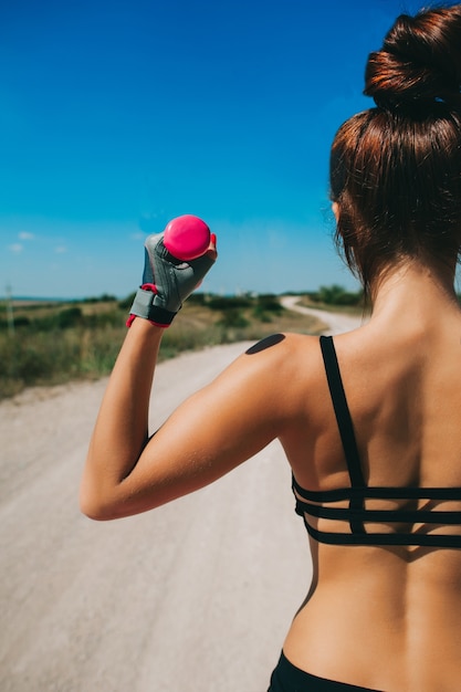 donna atletica pompare i muscoli con manubri