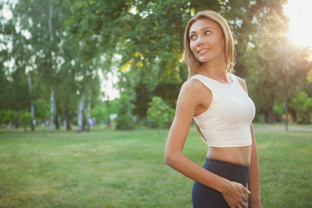 Donna atletica splendida che cammina nel parco