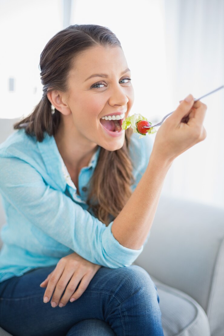 Foto donna attraente allegra che mangia insalata sana
