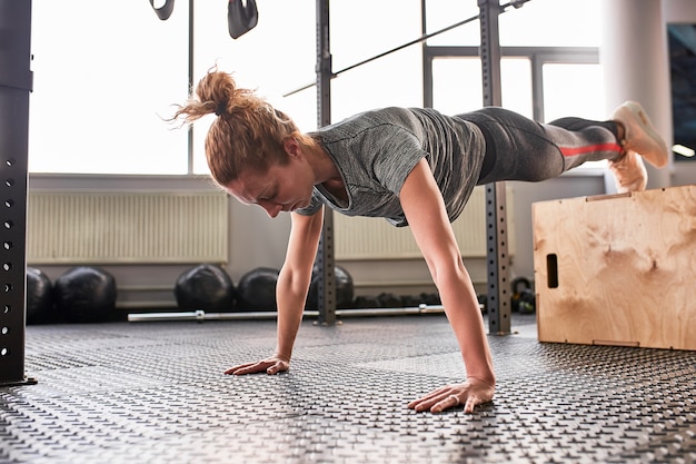 Donna attraente atletica strizzata in palestra.