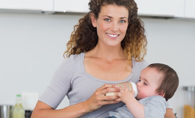 Donna attraente che alimenta il latte al bambino