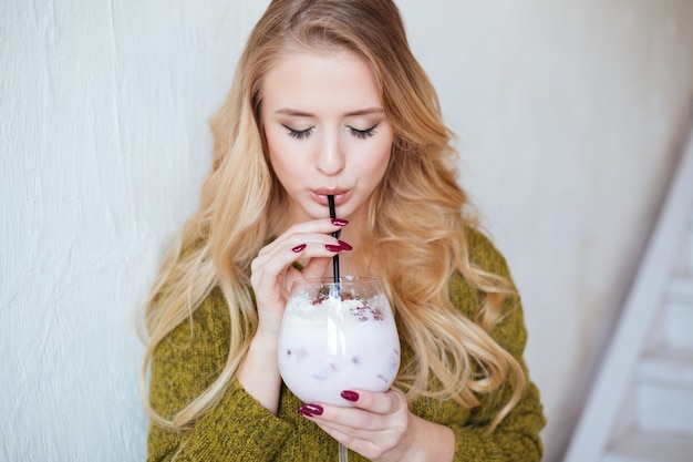 Donna attraente che beve cocktail al ristorante
