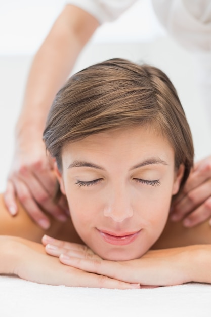 Donna attraente che riceve massaggio alla spalla al centro termale