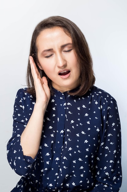 Donna attraente che sente mal di denti doloroso. Concetto di salute e cura dei denti.