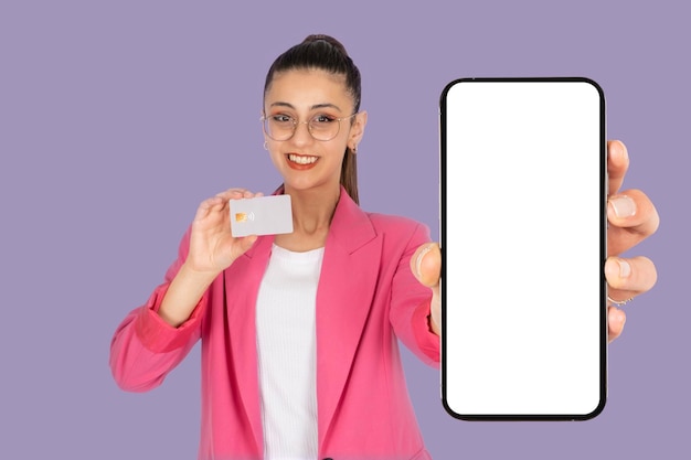 Donna attraente che tiene in mano una carta di credito bancaria e mostra un telefono cellulare bianco a schermo vuoto