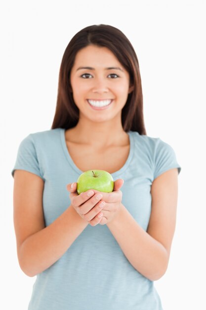 Donna attraente che tiene una mela verde