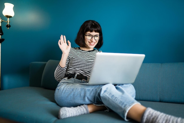 Donna attraente che utilizza computer portatile per la comunicazione, chat video. Riunione online in videochiamata.