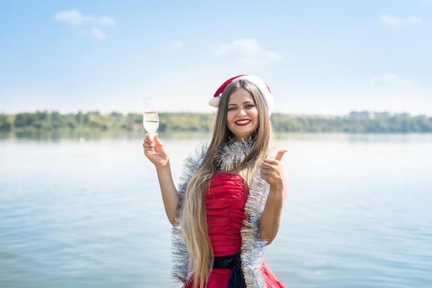 Donna attraente con i capelli lunghi e champagne sulla spiaggia