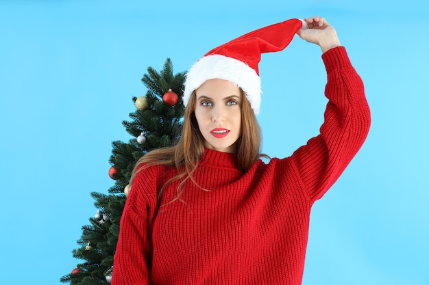 Donna attraente e albero di Natale su sfondo blu