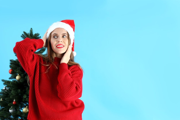 Donna attraente e albero di Natale su sfondo blu