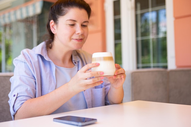 Donna attraente fuori che beve caffè