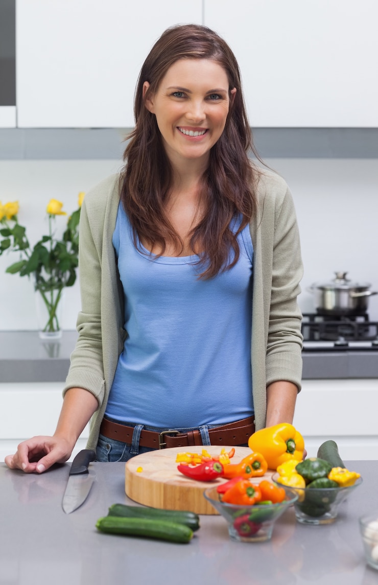 Foto donna attraente in piedi nella sua cucina