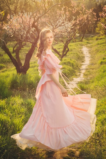 Donna attraente in vestito rosa che gode della natura