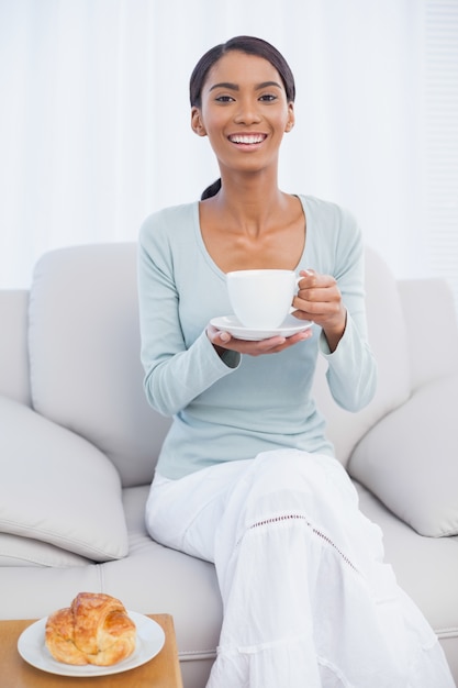 Donna attraente sorridente che mangia una prima colazione