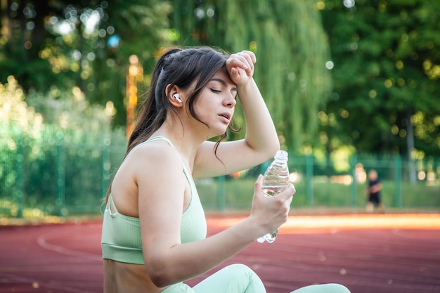 Donna attraente stanca dopo aver fatto jogging allo stadio