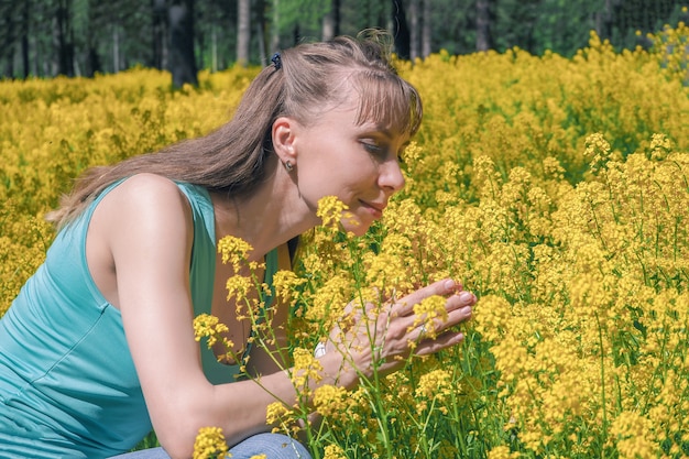 Donna attraente sul giardino di fiori giallo.