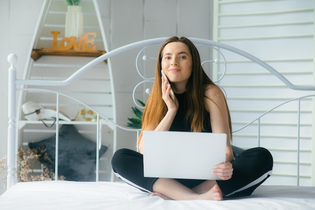 donna attraente utilizzando laptop e sorridente al mattino