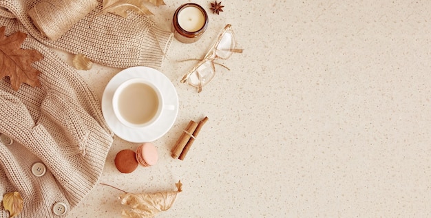 Donna autunno accogliente stile di vita maglione glassess candela Tempo di caffè estetico tra foglie autunnali amaretti bastoncini di cannella Spazio di copia Banner extra largo