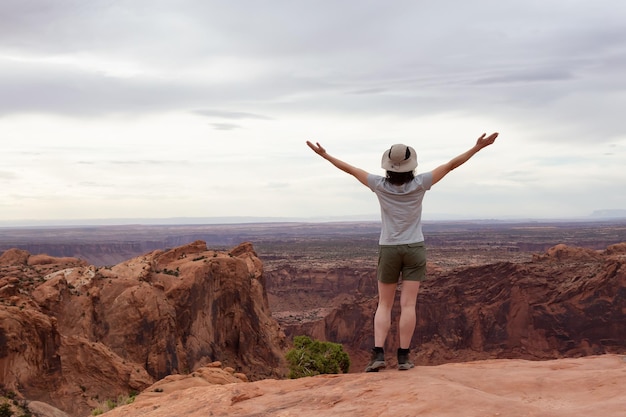 Donna avventurosa che fa un'escursione in un canyon del deserto con montagne di roccia rossa