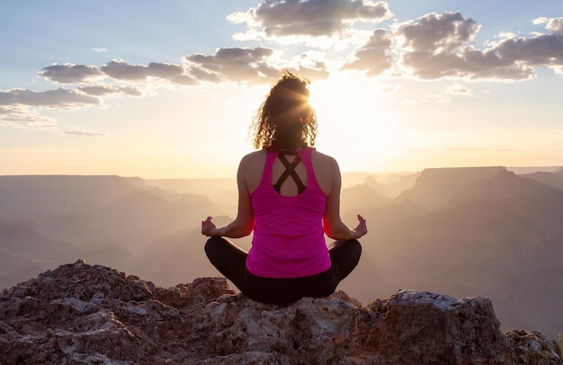 Donna avventurosa del viaggiatore che fa meditazione sul paesaggio americano della montagna rocciosa del deserto