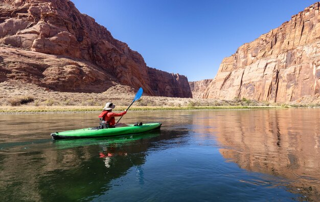 Donna avventurosa su un kayak che rema nel canyon del glen del fiume colorado in arizona