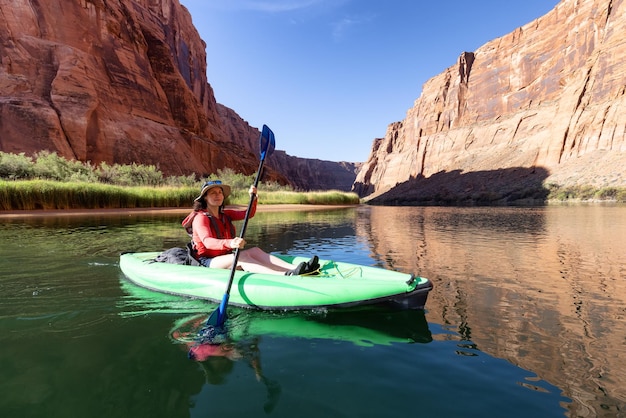 Donna avventurosa su un kayak che rema nel fiume colorado