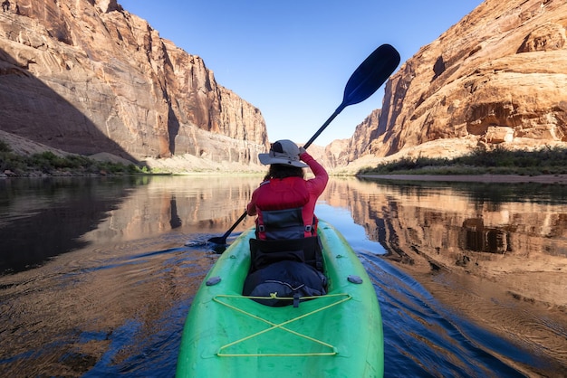 Donna avventurosa su un kayak che rema nel fiume Colorado