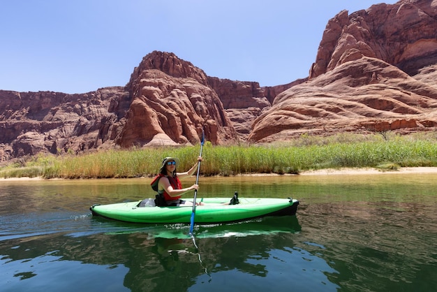 Donna avventurosa su un kayak che rema nel fiume Colorado