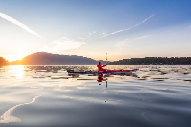 Donna avventurosa sul kayak da mare che rema nell'Oceano Pacifico