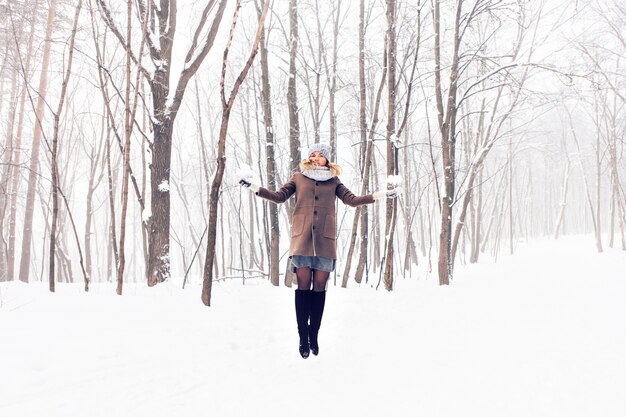 Donna bella inverno giocando con la neve