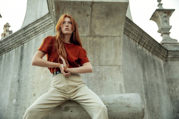 Donna bella rossa in posa sulla strada