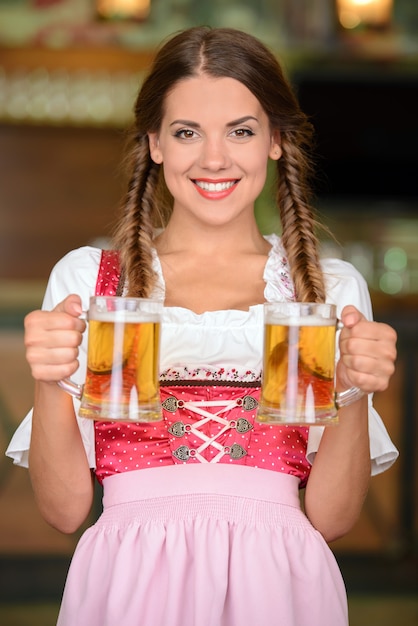 Donna bella, sexy cameriere con bicchieri di birra.