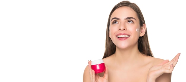 Donna bellezza viso primo piano ritratto isolato banner con spazio copia ragazza felice che applica crema per la pelle del viso isolata su sfondo bianco pelle sana