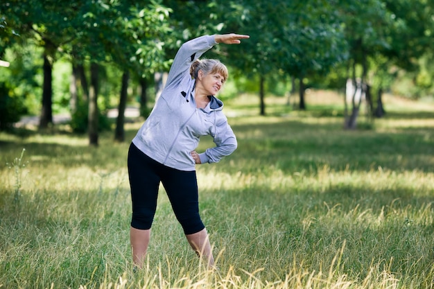 Donna bionda anziana che risolve nel parco