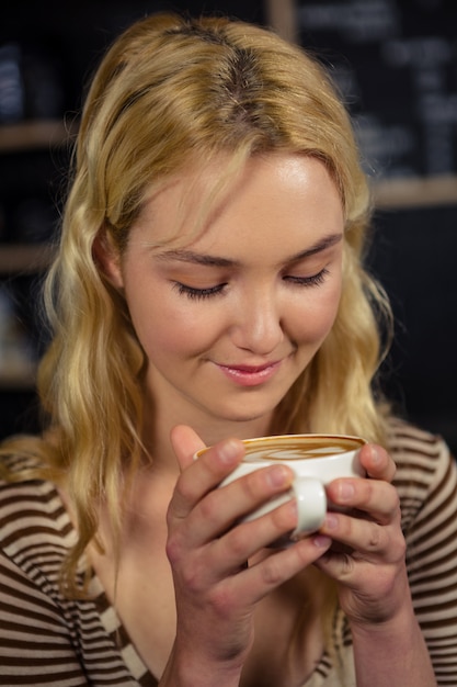 Donna bionda che beve una tazza di caffè