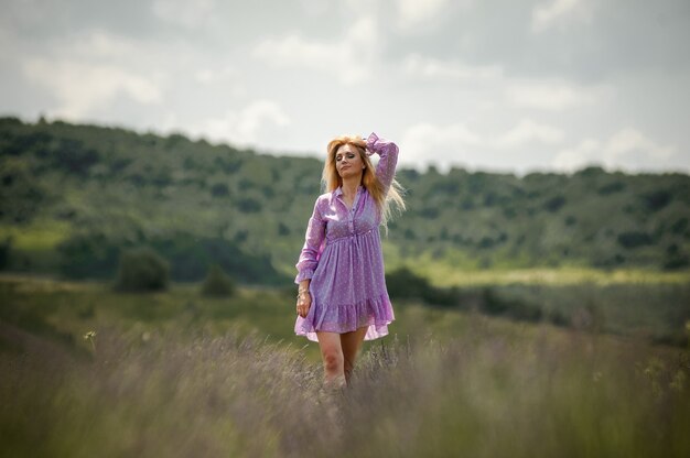 Donna bionda che cammina sul campo di lavanda