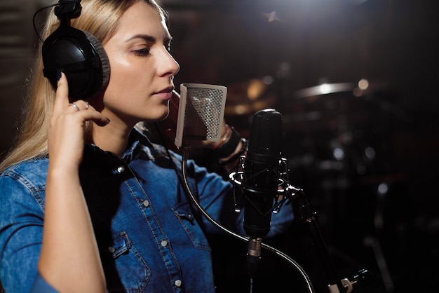 Donna bionda che canta in uno studio di registrazione