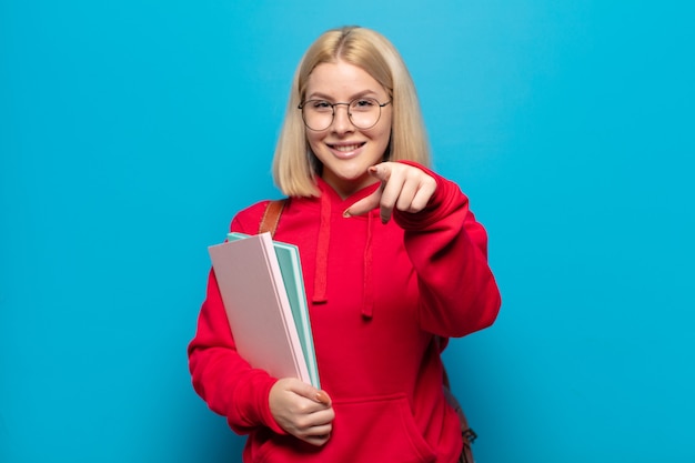 Donna bionda che indica con un sorriso soddisfatto, fiducioso e amichevole, scegliendo te