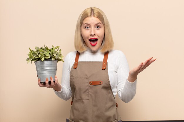 Donna bionda che si sente felice, sorpresa e allegra, sorridente con atteggiamento positivo, realizzando una soluzione o un'idea