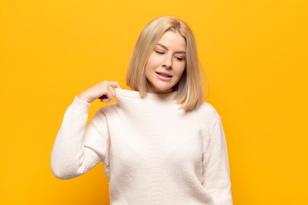 Donna bionda che si sente stressata, ansiosa, stanca e frustrata, tira il collo della camicia, sembra frustrata dal problema