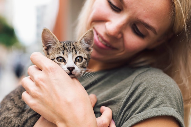 Donna bionda che tiene carino piccolo gatto