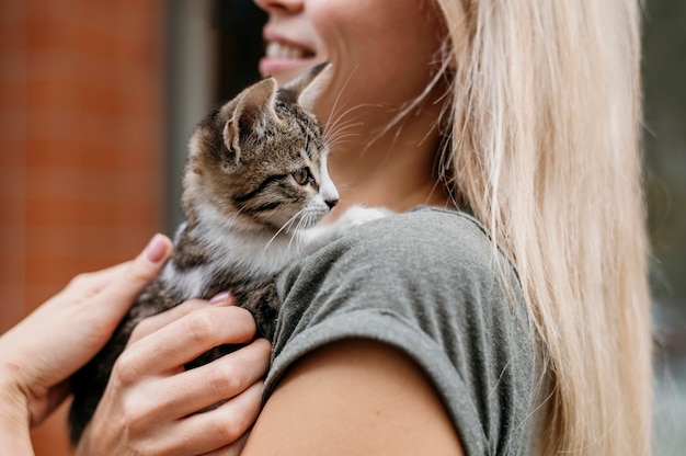 Donna bionda che tiene carino piccolo gatto