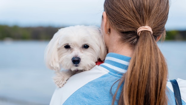 Donna bionda che tiene il cane maltese