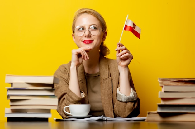 Donna bionda con la bandiera della Polonia e libri su giallo