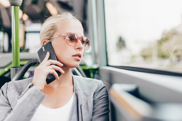 Donna bionda d'affari che viaggia in autobus