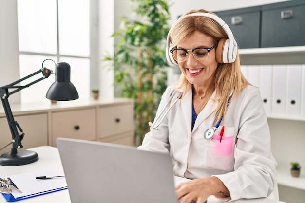 Donna bionda di mezza età che indossa l'uniforme del medico con teleconsulto medico presso la clinica