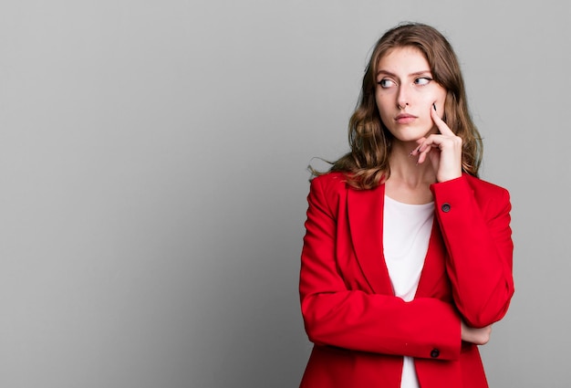 Donna bionda graziosa caucasica che indossa un concetto della donna di affari del blazer rosso