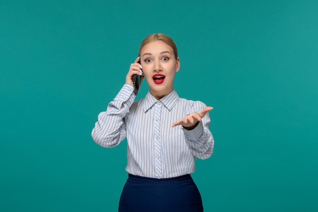 Donna bionda graziosa di affari in vestito dell'ufficio eccitato sulla telefonata