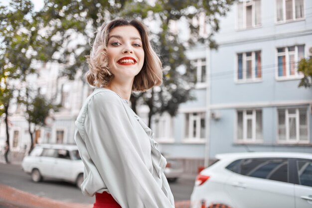 Donna bionda in gonna rossa all'aperto a camminare all'aria fresca
